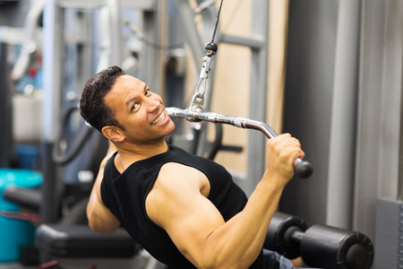 handsome mid age man doing pull-down workout in gym