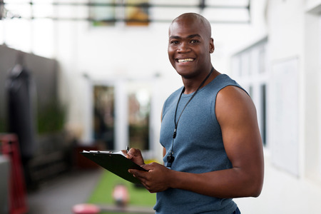 handsome african american male trainer with clipboardの写真素材