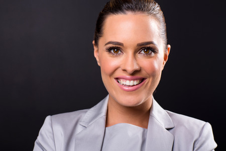 attractive young businesswoman looking at the camera on black background