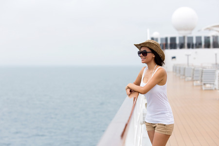 pretty young woman looking at the sea on a cruise shipの写真素材