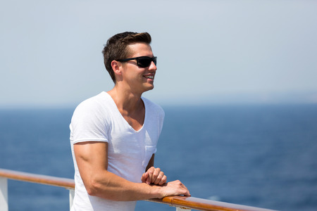 handsome man looking on sea from cruise deckの写真素材