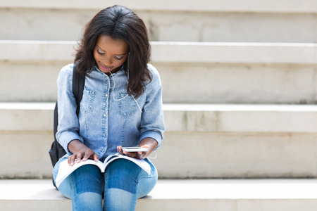 pretty african american college student reading a bookの写真素材