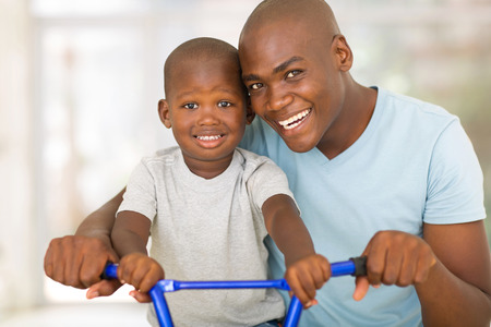 loving african american father teaching son to ride a bicycleの写真素材