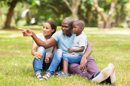 beautiful african family sitting on grass in the parkの写真素材