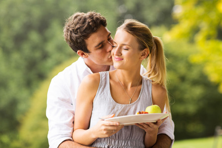 loving young man kissing girlfriend during breakfastの写真素材