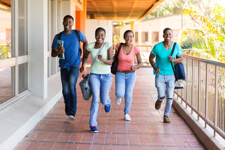 cheerful african college students running to lecture hallの写真素材