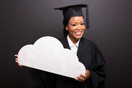 beautiful african college graduate holding cloud shape on black backgroundの写真素材