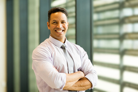 portrait of smiling mid age businessman in office building