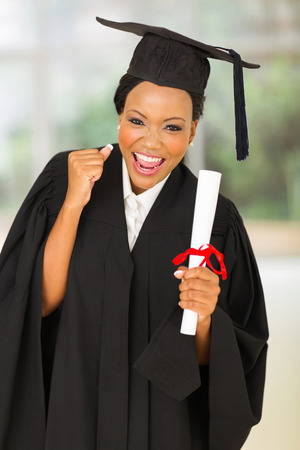 portrait of female graduate holding diploma in college hallの写真素材