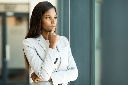 thoughtful african businesswoman looking through windowの写真素材