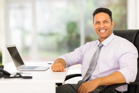 relaxed middle aged businessman sitting in officeの写真素材
