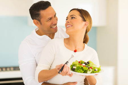beautiful couple eating salad at homeの写真素材