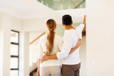 rear view of couple looking around their new homeの写真素材