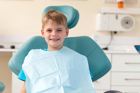 portrait of little boy sitting in dentist's officeの写真素材