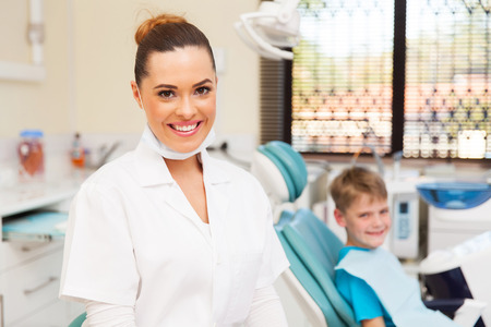 young female dentist and little patient in officeの写真素材