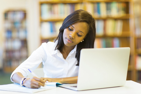 pretty female college student studying in library