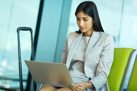 indian businesswoman using laptop while waiting for her flightの写真素材
