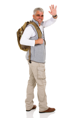 cheerful senior tourist waving goodbye isolated on whiteの写真素材