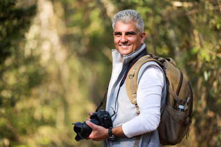 good looking mid age man taking photos in the nature