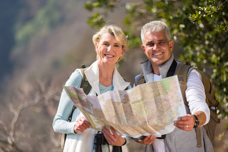 cheerful mid age couple hikers holding a mapの写真素材