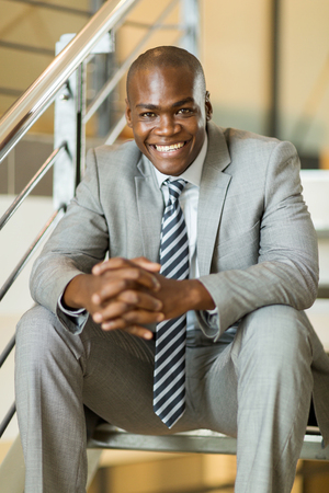 relaxed african businessman sitting on stairsの写真素材