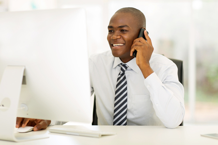 smiling african american businessman making phone callの写真素材