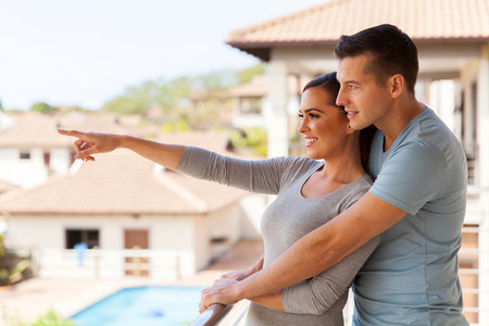 happy young couple relaxing on balcony at homeの写真素材