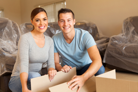 happy young couple unpacking boxes and moving into a new homeの写真素材