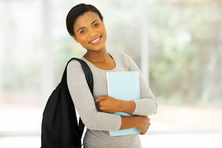 portrait of beautiful african college student holding a bookの写真素材