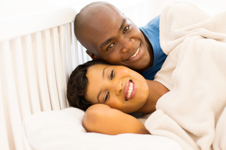 portrait of happy young african couple in bedの写真素材