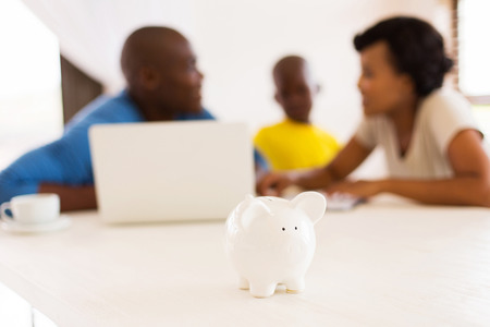 african family doing some financial planning with piggybank close upの写真素材