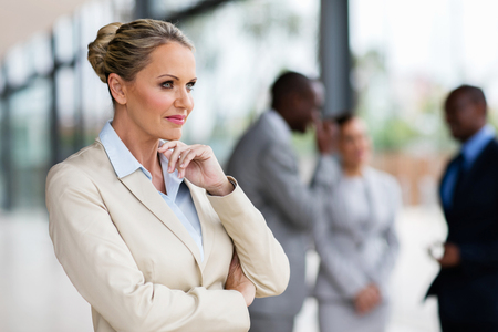thoughtful middle aged businesswoman in modern officeの写真素材