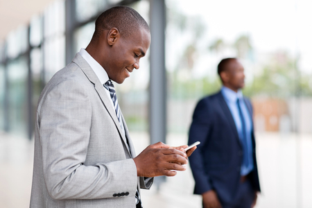 african businessman using smart phone in modern officeの写真素材