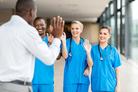rear view of patient waving goodbye to friendly medical teamの写真素材