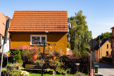 Colorful house on a sunny day with vibrant garden in a quiet neighborhoodの写真素材