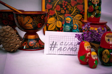 A leaflet with the hashtag "Stay at home". All around are Russian dishes made of wood, nesting dolls, decorative board.の写真素材