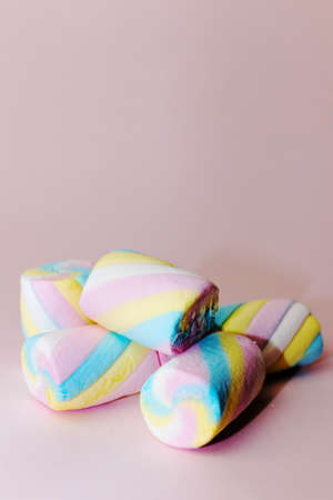 Colorful marshmallows candy on a pink background - verticalの写真素材