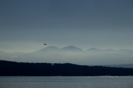 Seaplane flying over the silhouette of Mountains
