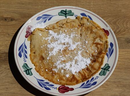 close up of pancake with powdered sugar