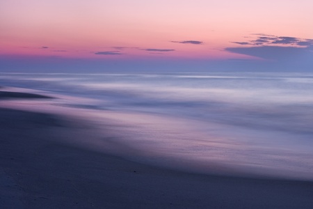 A beautiful pastel colored sunset on a quiet, secluded beach.
