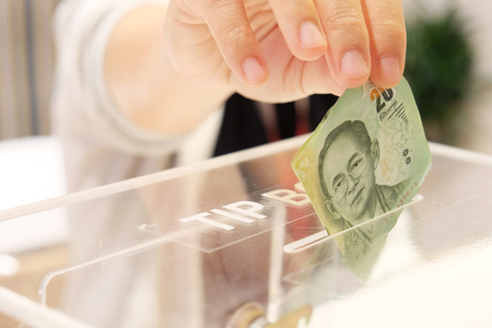 Giving money into tip boxの写真素材