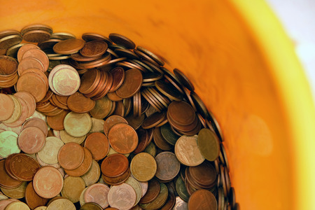 Coins in plastic bucket for donation in Bhuddismの写真素材