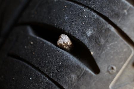 Small stone in the tire tread of carの写真素材