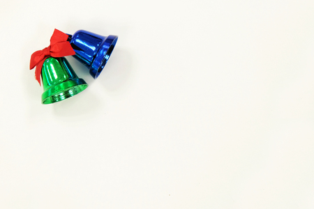 Shining green and blue bell with red ribbon on white background paper for Christmas holiday eventの写真素材