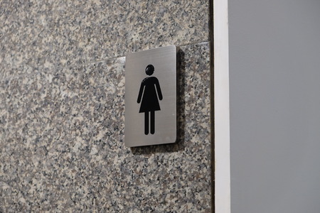 Metallic icon symbol on the shiny tile wall for woman toiletの写真素材