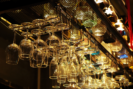 Wine glass hanging upside down at bar in night clubの写真素材