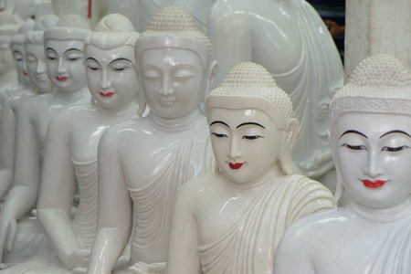 Row of white marble Lord Buddha statue in Burmese art style in meditation sitting positionの写真素材