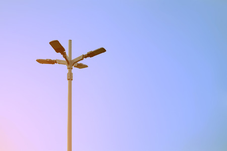Electrical light pole in cross shape with background of clear skyの写真素材