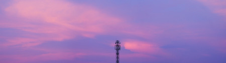 Top of cellular antenna in the center of panorama of dusk cloud blue and pink skyの写真素材
