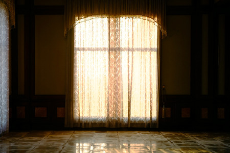 Curtain of window at wall with dusk sunlightの写真素材